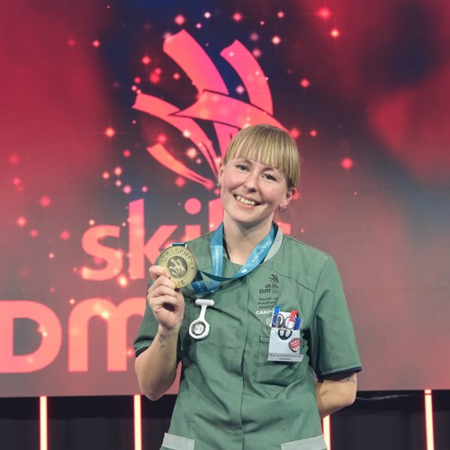 Caroline Kammer Olesen viser sin guldmedalje på podiet