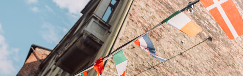Flagline med flag fra mange forskellige lande foran en bygning